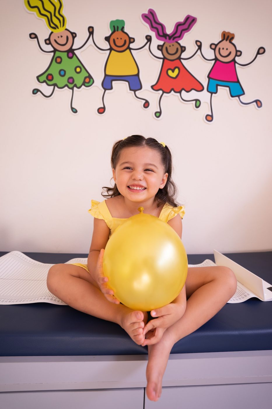Smiling young girl holding a balloon in a paediatric clinic